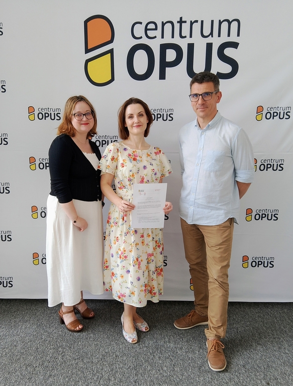 Trzy osoby trzymające dyplom