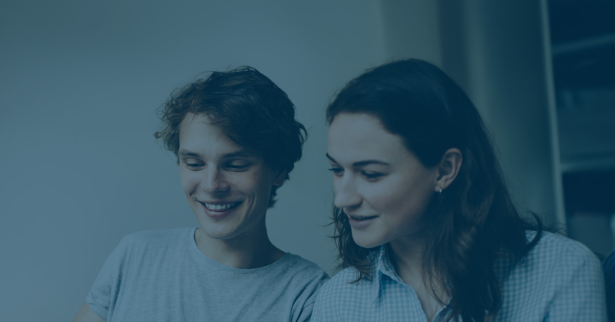 dwie młode osoby pracujące nad czymś razem