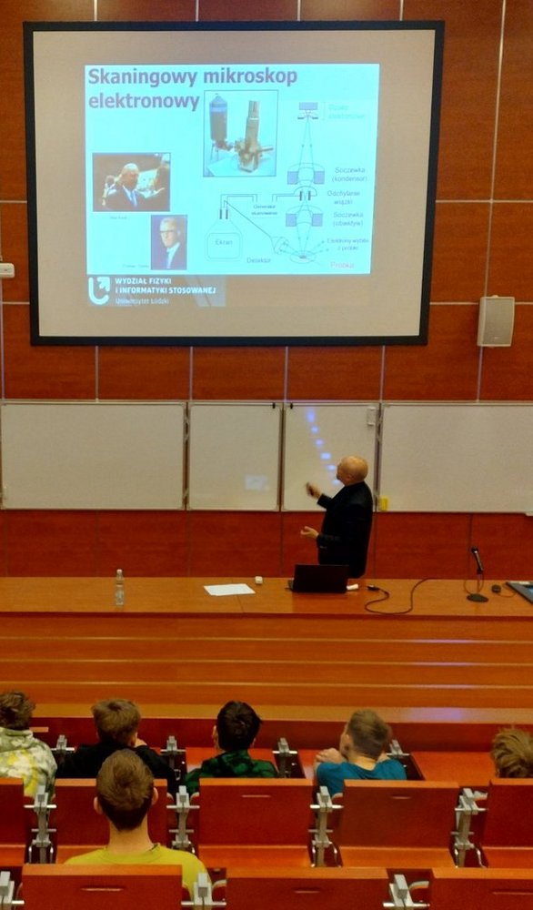 Uczniowie Szkoły Podstawowej nr 142 w Łodzi uczestniczą w zajęciach w laboratoriach Wydziału Fizyki i Informatyki Stosowanej Uniwersytetu Łódzkiego. Obserwują eksperymenty, mikroskopy i urządzenia do detekcji promieniowania kosmicznego, a prowadzący wyjaśniają zasady działania sprzętu i pokazują zastosowania fizyki w praktyce.