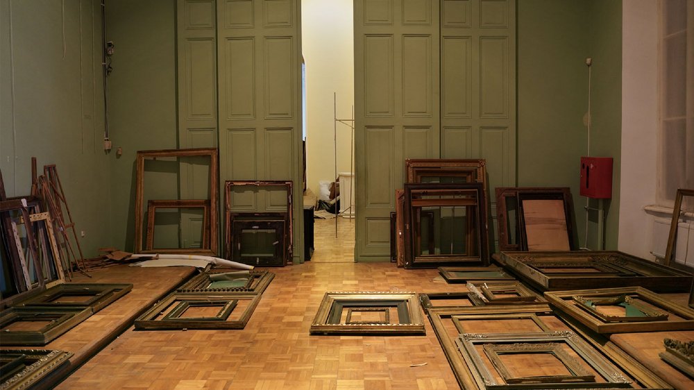 wnętrze pomieszczenia z ramami na obrazy