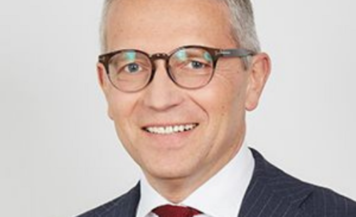 mężczyzna w garniturze i w okularach na jasnym tle