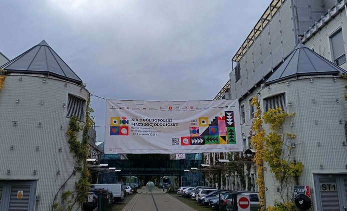 Baner rozpięty między budynkami. Napis: XIX Ogólnopolski Zjazd Socjologiczny