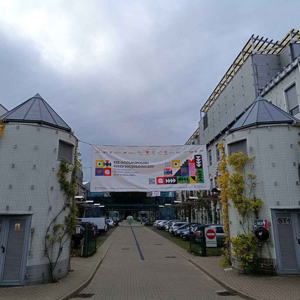 Baner rozpięty między budynkami. Napis: XIX Ogólnopolski Zjazd Socjologiczny