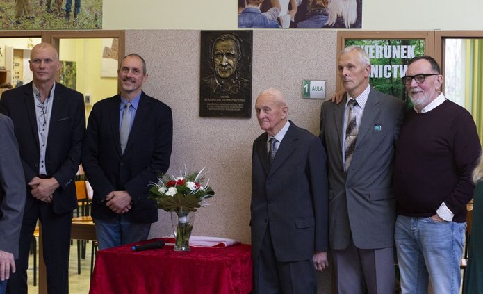 Zdjęcie braci i syna dr Dobrowolskiego pod tablica upamiętniajaca jego imię.