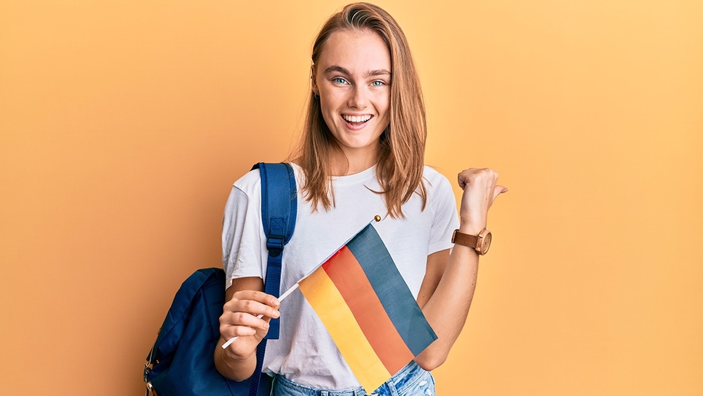 Uśmiechnięta dziewczyna z flagą Niemiec.