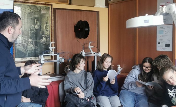 Uczniowie Szkoły Podstawowej nr 142 w Łodzi uczestniczą w zajęciach w laboratoriach Wydziału Fizyki i Informatyki Stosowanej Uniwersytetu Łódzkiego. Obserwują eksperymenty, mikroskopy i urządzenia do detekcji promieniowania kosmicznego, a prowadzący wyjaśniają zasady działania sprzętu i pokazują zastosowania fizyki w praktyce.