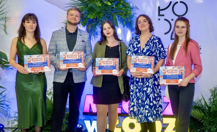 Grupa osób pozujących do zdjęcia i trzymających dyplomy