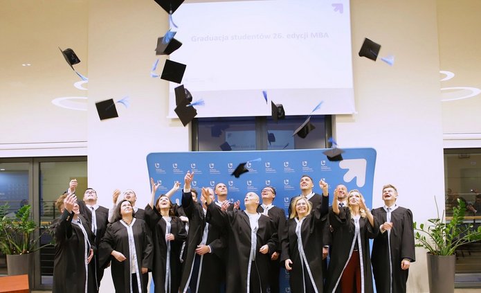 Grupa 26 edycji studiów MBA podczas wyrzutu biretów