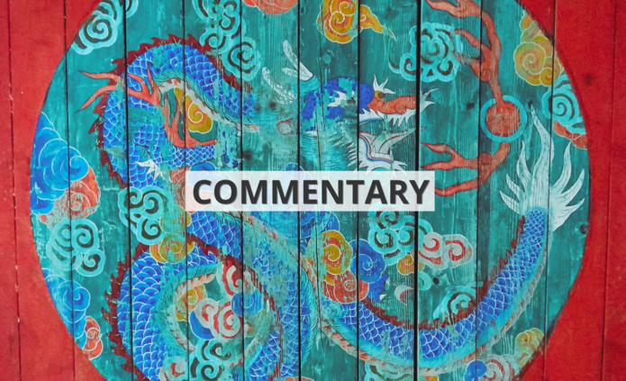 Namalowany na czerwonym drewnie wielobarwny okrąg ze smokiem we wschodnioazjatyckim stylu z napisem ‘commentary’ / A multicolored circle with a dragon painted on red wood in East Asian style with the inscription 'commentary'