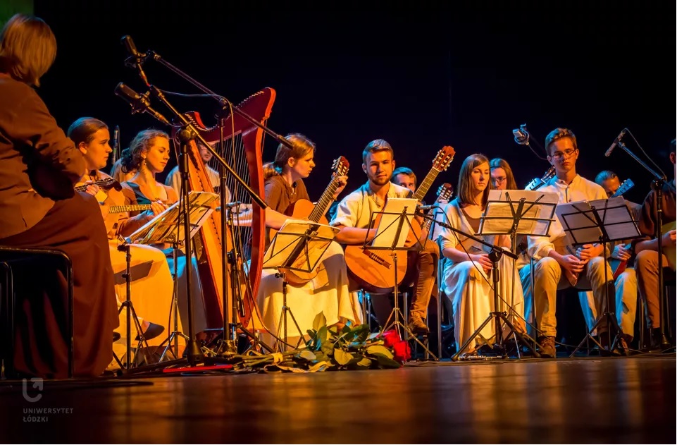 Członkowie Akademickiego Zespołu Muzyki Narodów Słowiańskich "Bałałajki" siedzą na scenie z instrumentami